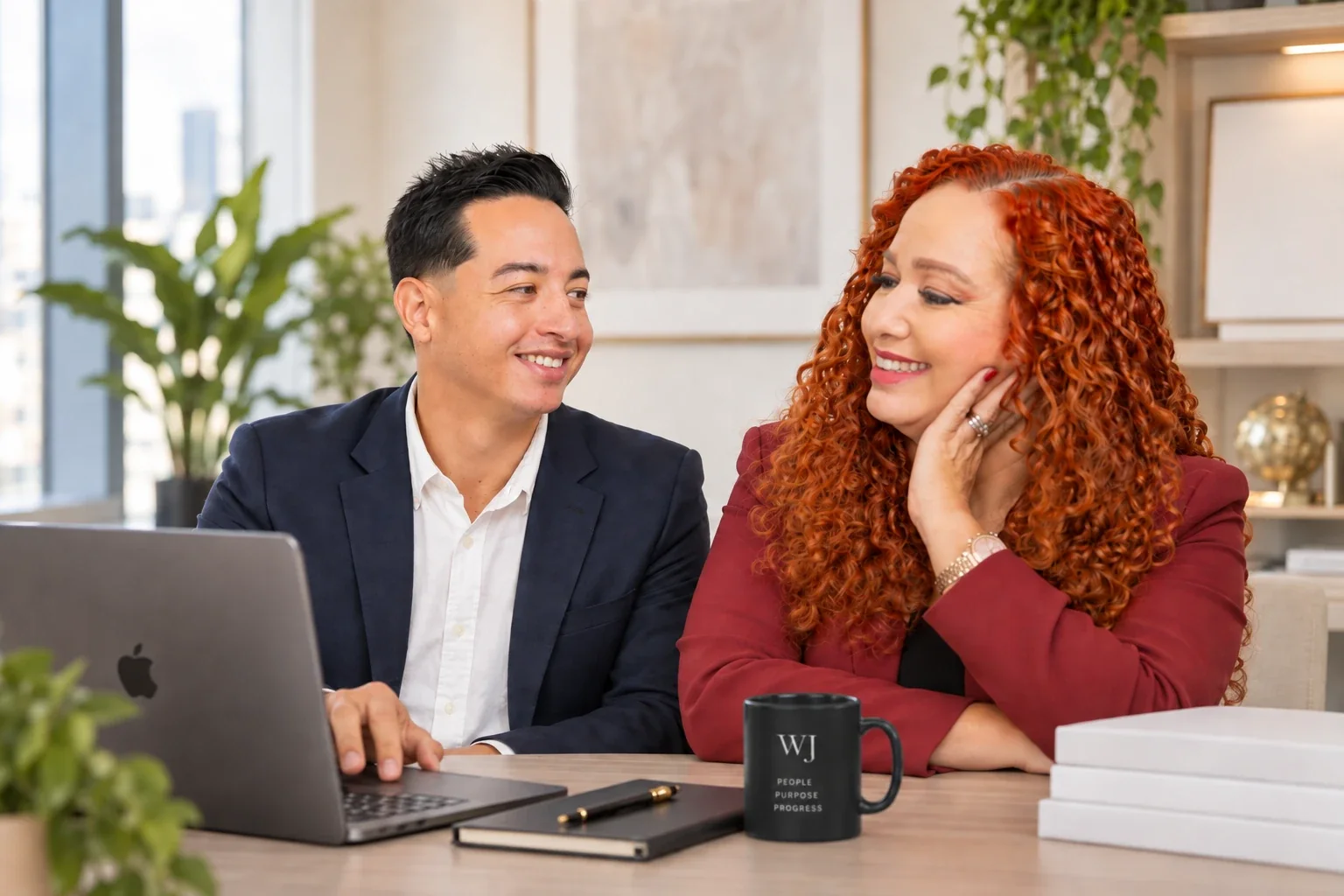 Wanda y Javier de WJ Insurance Group trabajando juntos en la oficina